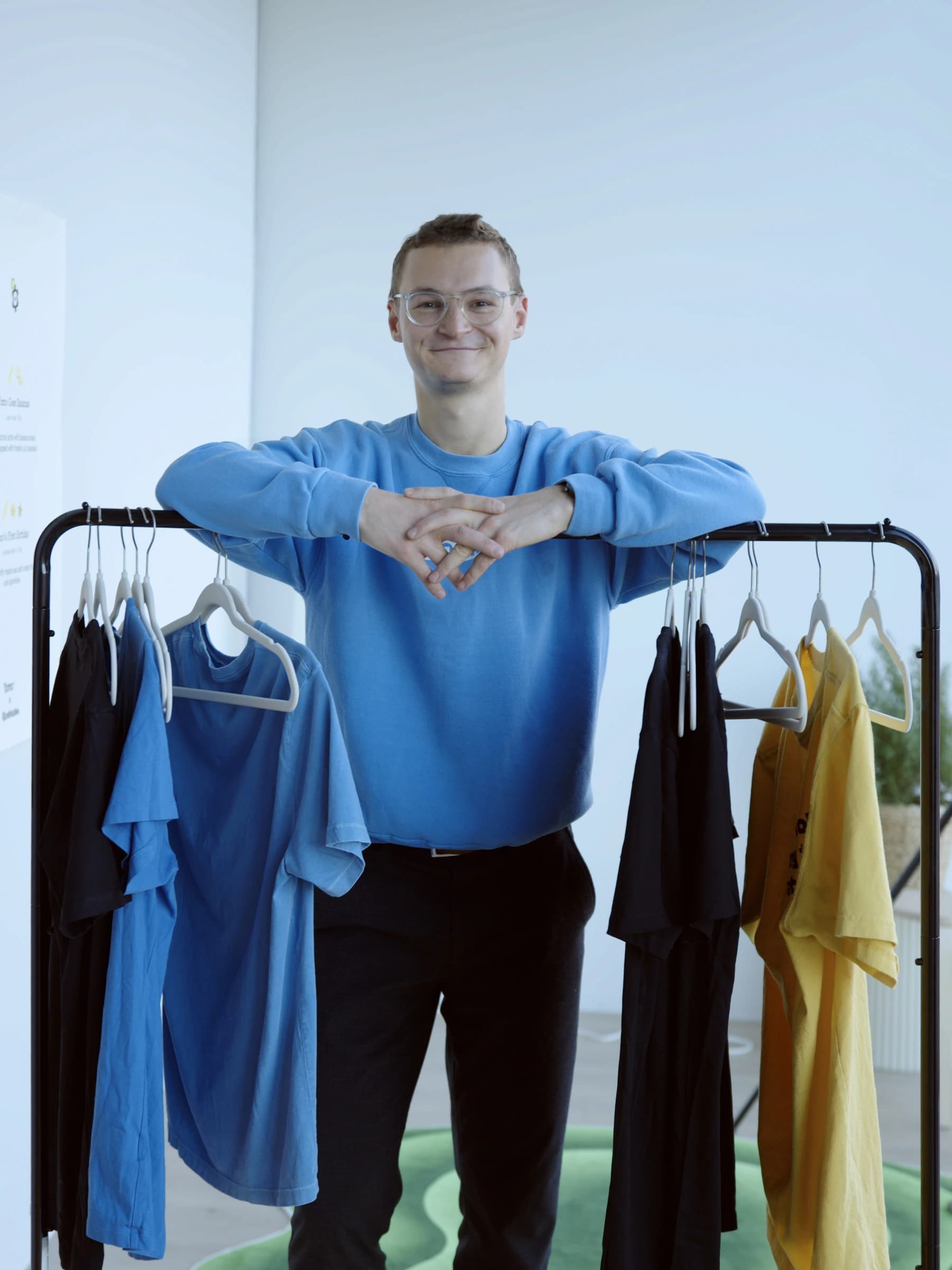 Team member beside the Tomo merch rack